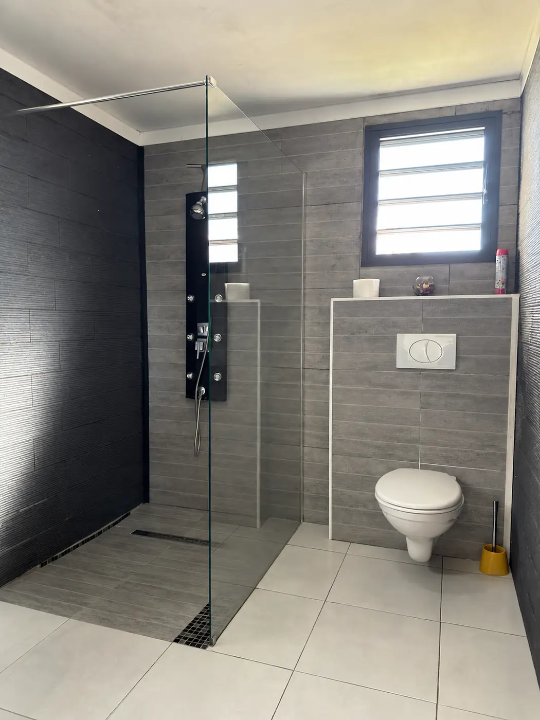 Salle d'eau de La Caz'à Chisy avec grande douche à l'italienne, colonne de douche et WC suspendu