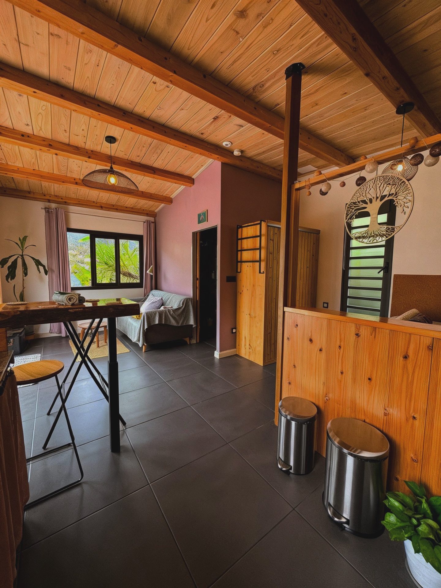 Intérieur du bungalow Le Poule d'Eau à Cilaos — espace de vie ouvert sous charpente bois, ambiance cocooning face aux montagnes