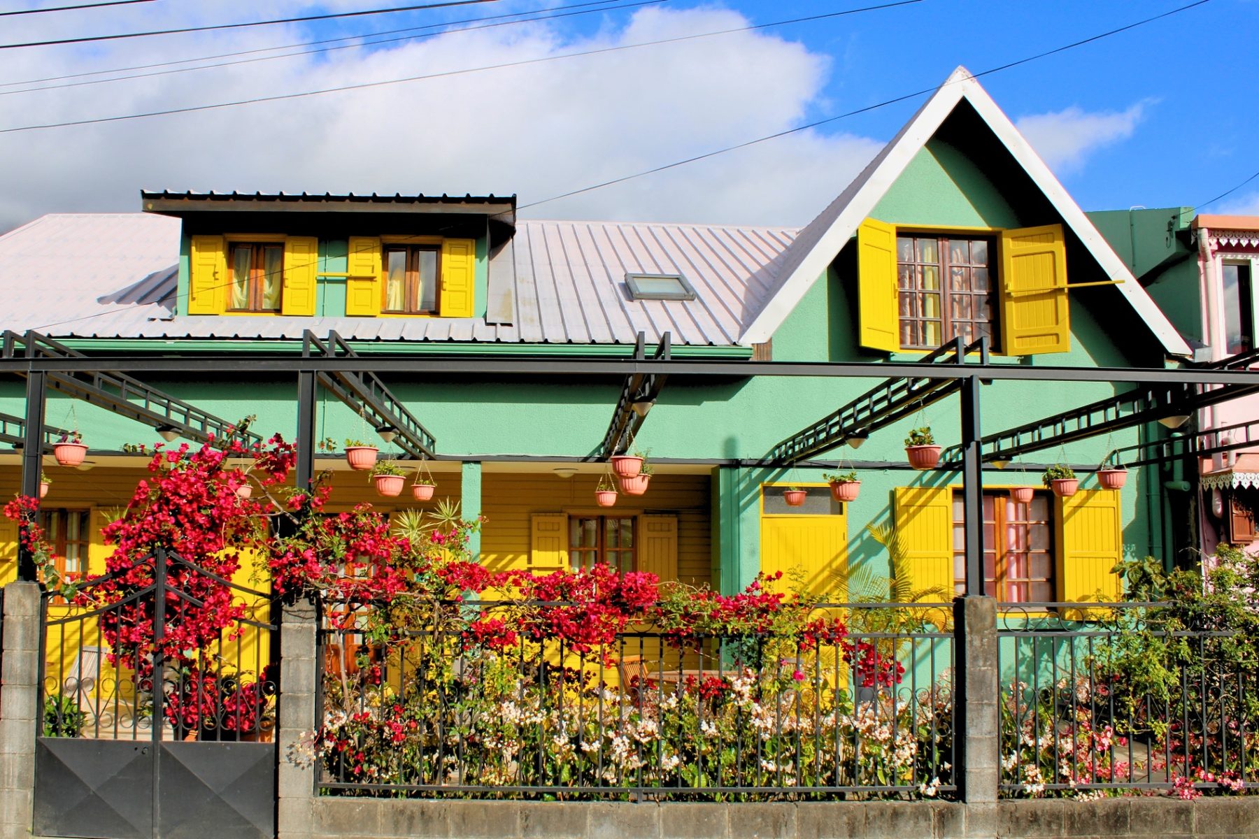 Photo de présentation de L'Habitation Firmant à Cilaos — façade créole colorée et fleurie au cœur du village