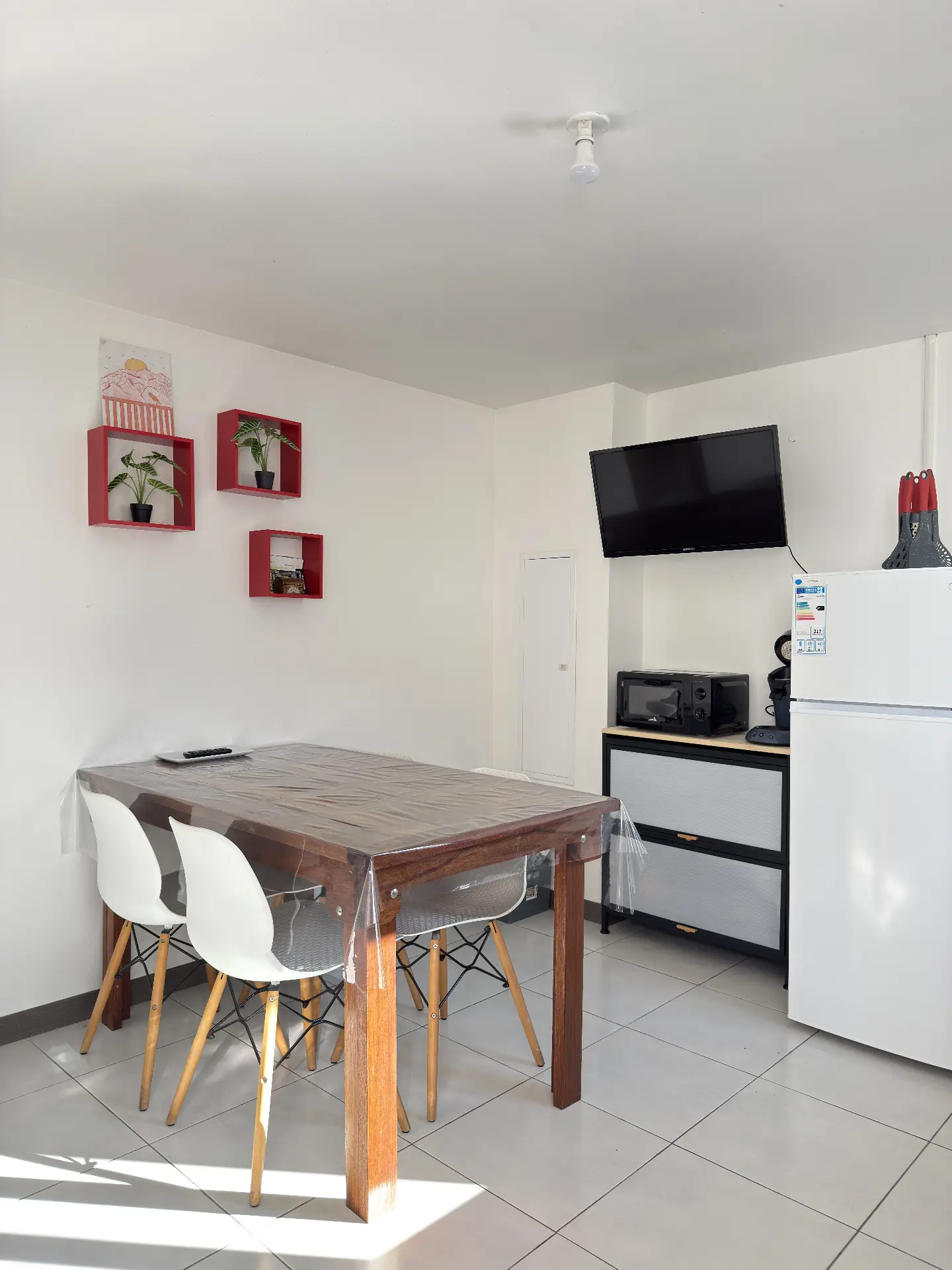 Espace repas de La Caz'à Chisy à Bras-Sec avec table à manger en bois, chaises et télévision