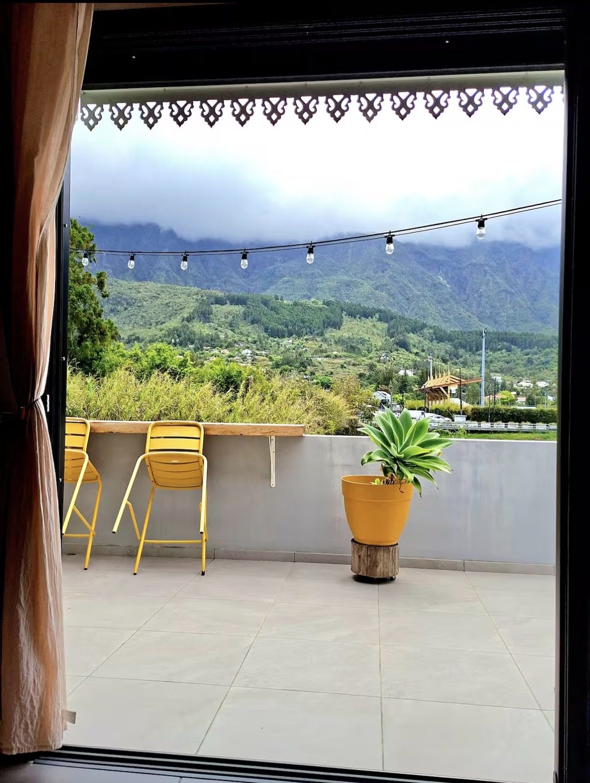 Terrasse en bois du bungalow Le Poule d'Eau à Cilaos avec vue panoramique sur les montagnes du Cirque de Cilaos, La Réunion
