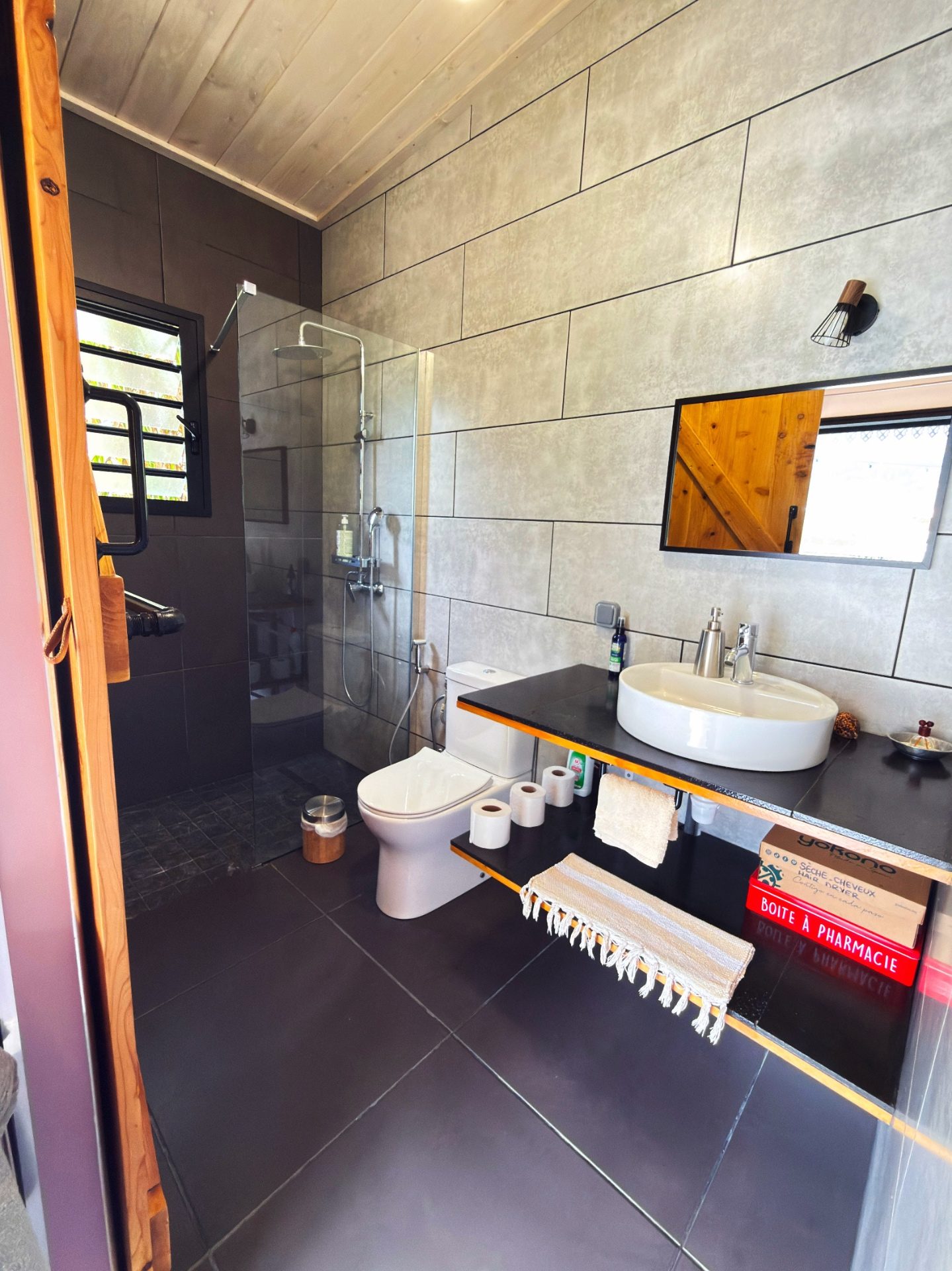 Salle de bain privative du bungalow Le Poule d'Eau à Cilaos avec douche à l'italienne, vasque et rangements
