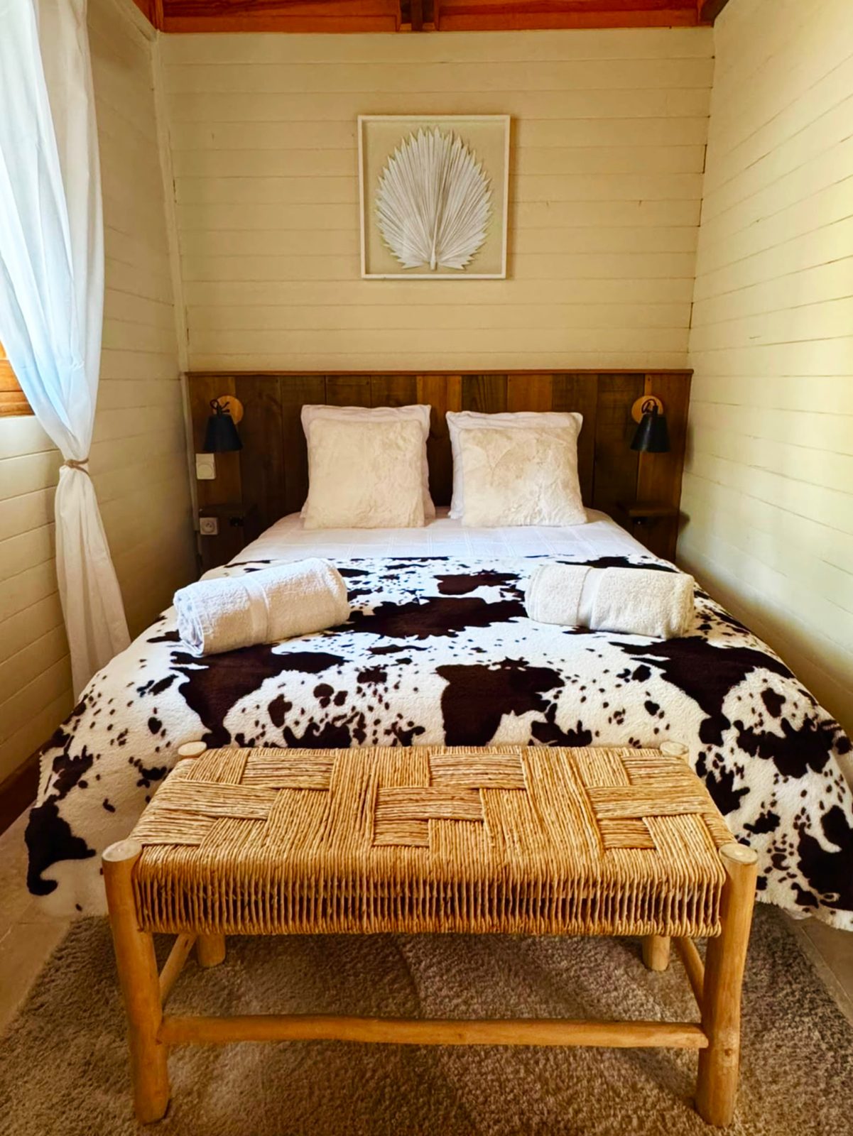 Vue de face de la troisième chambre double du Chalet Des Sens à Cilaos avec banc tressé en pied de lit