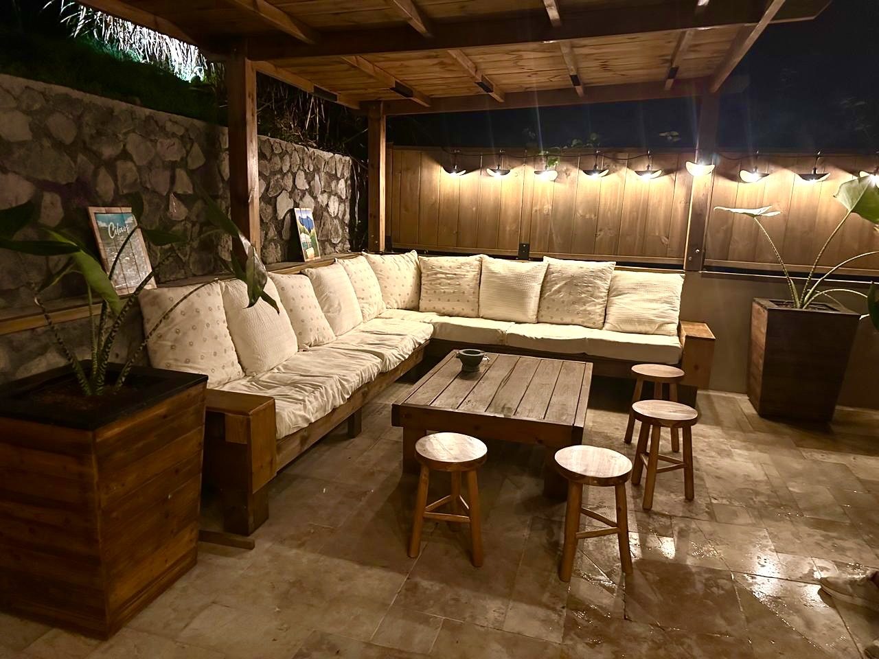 Salon extérieur du Chalet Des Sens à Cilaos illuminé de nuit, ambiance chaleureuse sous la pergola