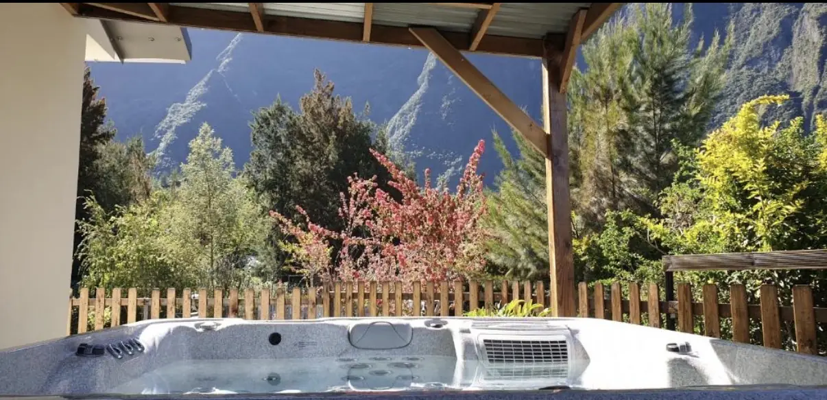 Jacuzzi extérieur couvert de La Caz'à Chisy à Bras-Sec, Cilaos, face aux remparts du cirque et à la végétation