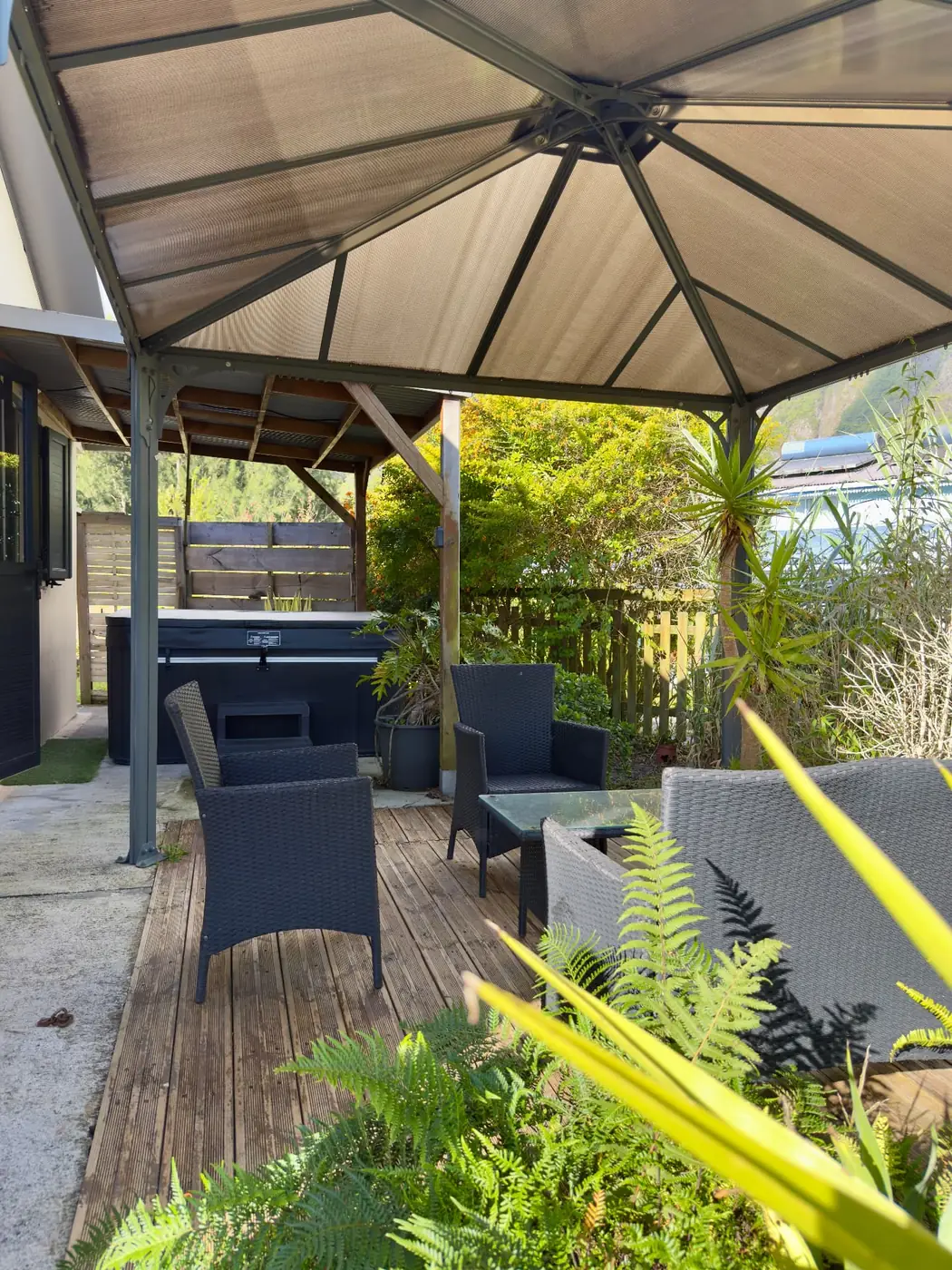 Gazebo couvert de La Caz'à Chisy à Bras-Sec abritant le jacuzzi et un salon d'extérieur sur terrasse en bois