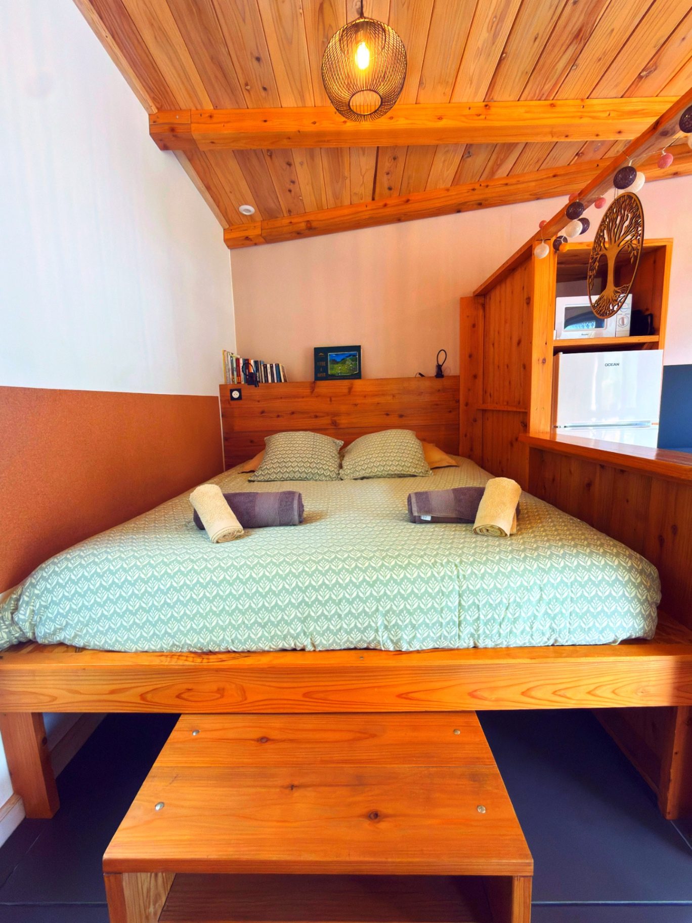 Chambre du bungalow Le Poule d'Eau à Cilaos avec lit King size et charpente bois apparente, séjour pour 2 personnes