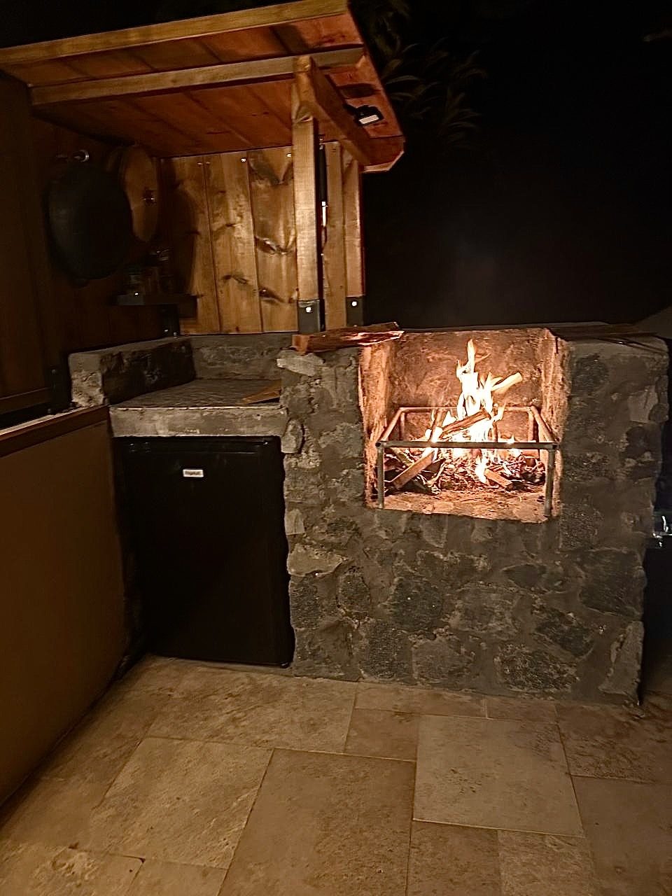 Feu de bois allumé le soir dans la cuisine d'été du Chalet Des Sens à Cilaos