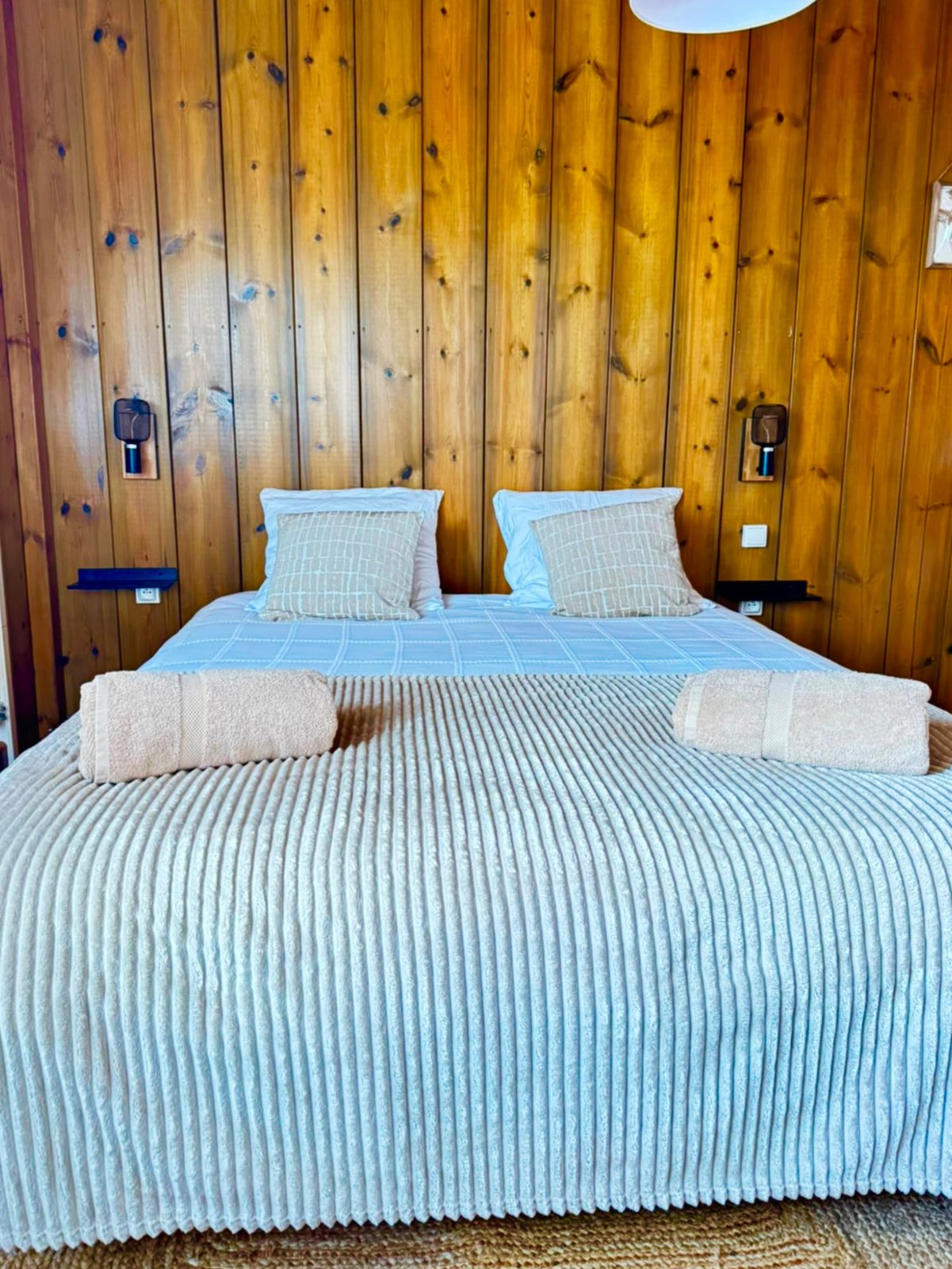 Lit double de la deuxième chambre du Chalet Des Sens à Cilaos avec liseuses et linge de lit préparé