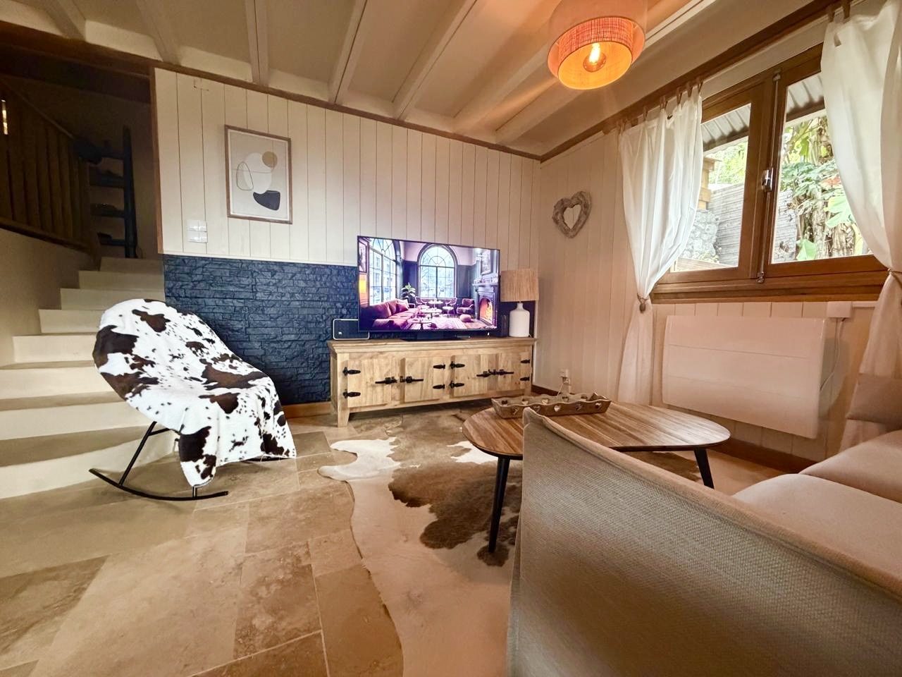 Salon intérieur chaleureux du Chalet Des Sens à Cilaos avec canapé, télévision et ambiance chalet de montagne